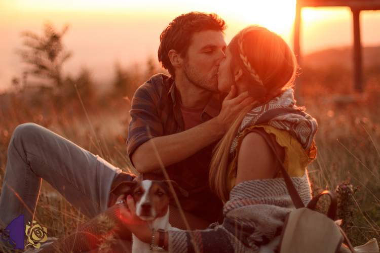 Girl and boy in a field kissing